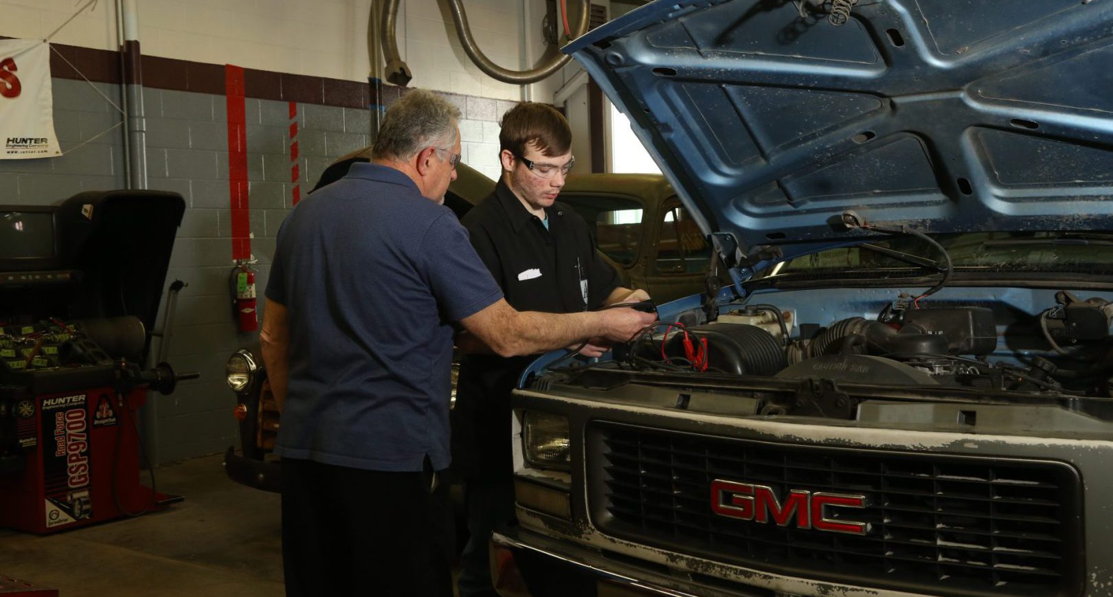 Student and Instructor working on a car