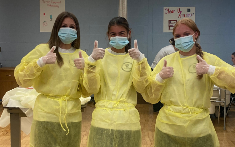 3 Health Occupations Students Standing together with their thumbs up.